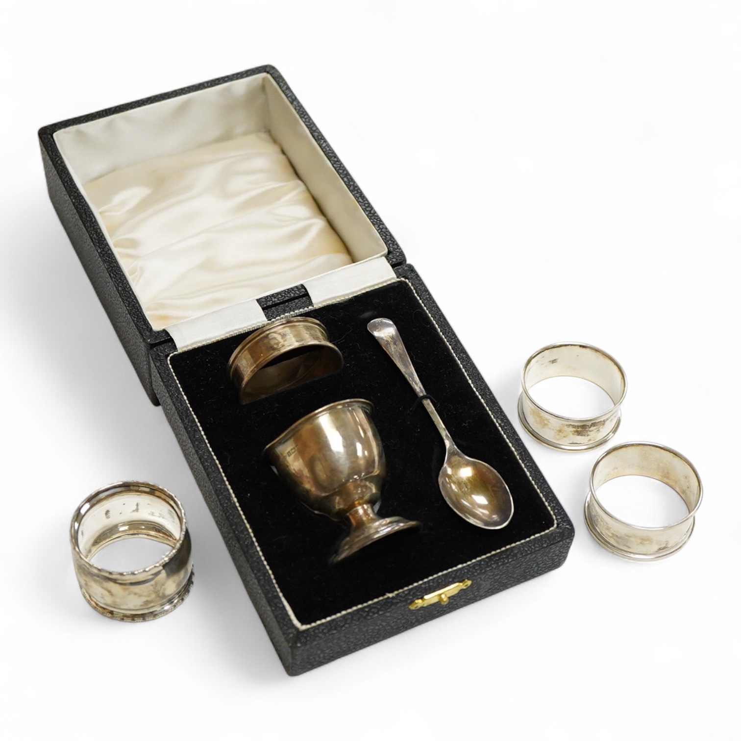 An Elizabeth II cased silver christening trio, Birmingham, 1959/60, together with three silver napkin rings.